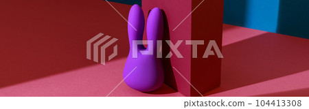 Violet dildo vibrator for clitoris with pink gift box on colored background. Sex toy for adult Violet dildo vibrator for clitoris with pink gift box on colored background. Sex toy for adult 104413308