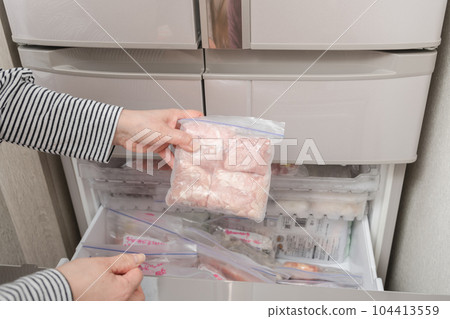 [Housewife taking out chicken thighs from the freezer] 104413559