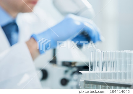 Scientist looks into a microscope near the laboratory, close-up 104414045