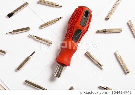 red screwdriver, white background and bits, spare parts 104414741