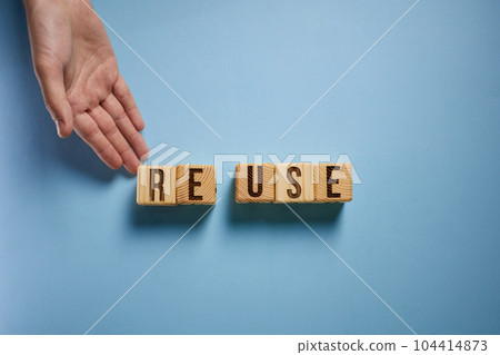 On a blue background, the surface of the white cubes with the inscription - REUSE On a blue background, the surface of the white cubes with the inscription - REUSE 104414873