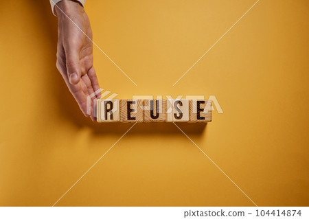 On a yellow surface, white cubes with the inscription - REUSE 104414874