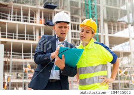Civil engineers checking work process in construction site 104415062