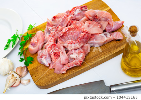 Raw sliced rabbit lying on wooden cutting board with seasonings Raw sliced rabbit lying on wooden cutting board with seasonings 104415163