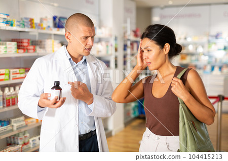 Pharmacist offering headache medicine to patient at pharmacy closeup Pharmacist offering headache medicine to patient at pharmacy closeup 104415213