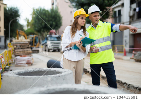 Master builder and architect talking in construction area 104415691
