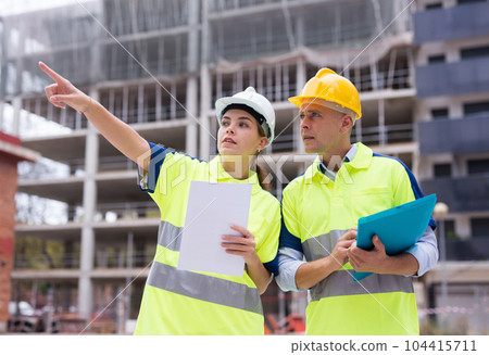 Two qualified engineers are discussing a construction plan 104415711