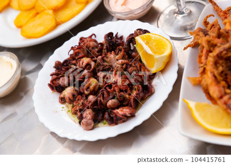 Small fried octopus with sour cream and vegetables Small fried octopus with sour cream and vegetables 104415761