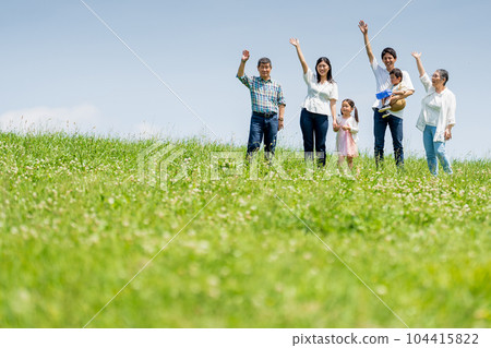 站在藍天小山上的一家三口 104415822