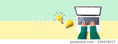 Person using a laptop computer and light bulbs Person using a laptop computer and light bulbs 104416017