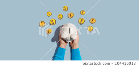Person holding piggy bank with hand drawn coins 104416018