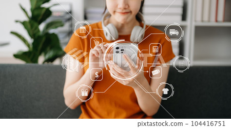Woman hand using a laptop, smartphone and tablet and writing notebook at the office of her business online shopping. In home with virtual icon Woman hand using a laptop, smartphone and tablet and writing notebook at the office of her business online shopping. In home with virtual icon 104416751