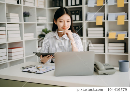 Asian businesswoman working in the office with working notepad, tablet and laptop documents in office 104416779
