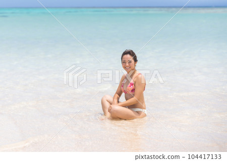 Young woman in bikini smiling on shallow beach Young woman in bikini smiling on shallow beach 104417133