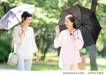 撐著陽傘行走的中年婦女 104417968