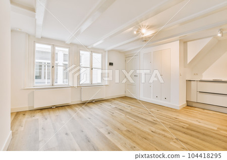 an empty living room with wood floors and white trim on the walls in this photo is taken from the inside 104418295