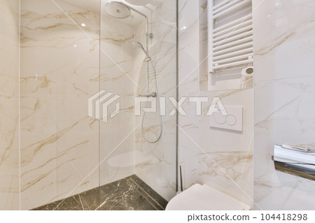 a bathroom with white marble walls and flooring, including a shower head mounted on the wall next to the toilet a bathroom with white marble walls and flooring, including a shower head mounted on the wall next to the toilet 104418298