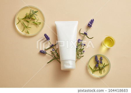A tube in white color is decorated with purple lavender flowers and some glassware of yellow essential oil. Gentle skin care concept with empty label tube extracted from Lavender (Lavandula) A tube in white color is decorated with purple lavender flowers and some glassware of yellow essential oil. Gentle skin care concept with empty label tube extracted from Lavender (Lavandula) 104418683