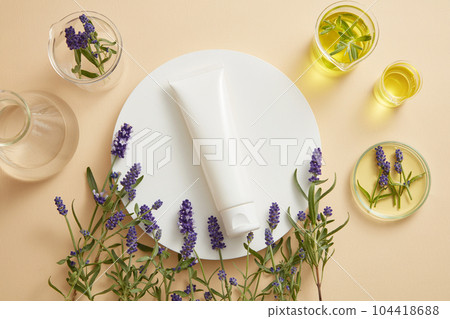 White round podium with unbranded tube placed on and many flowers arranged at the bottom. Lavender (Lavandula) is a natural antioxidant that works to prevent and reverse disease 104418688