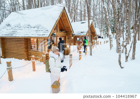 Woman tourist Visiting in Furano, Traveler in Sweater sightseeing Ningle Terrace Cottages with Snow in winter. landmark and popular for attractions in Hokkaido, Japan. Travel and Vacation concept Woman tourist Visiting in Furano, Traveler in Sweater sightseeing Ningle Terrace Cottages with Snow in winter. landmark and popular for attractions in Hokkaido, Japan. Travel and Vacation concept 104418967
