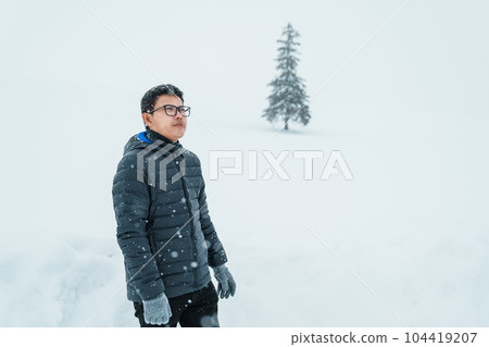 man tourist Visiting in Biei, Traveler in Sweater sightseeing Christmas tree with Snow in winter season. landmark and popular for attractions in Hokkaido, Japan. Travel and Vacation concept man tourist Visiting in Biei, Traveler in Sweater sightseeing Christmas tree with Snow in winter season. landmark and popular for attractions in Hokkaido, Japan. Travel and Vacation concept 104419207