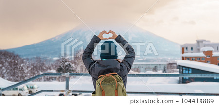 Woman tourist Visiting in Niseko, Traveler in Sweater sightseeing Yotei Mountain with Snow in winter season. landmark and popular for attractions in Hokkaido, Japan. Travel and Vacation concept 104419889