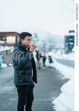 man tourist holding hot Coffee or Tea paper cup with snow in winter season during travel in Niseko. landmark and popular for attractions in Hokkaido, Japan. Travel and Vacation concepts man tourist holding hot Coffee or Tea paper cup with snow in winter season during travel in Niseko. landmark and popular for attractions in Hokkaido, Japan. Travel and Vacation concepts 104420027