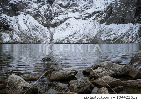 Czarny Staw pod Rysamy or Black Pond lake near the Morskie Oko Snowy Mountain Hut in Polish Tatry mountains, drone view, Zakopane, Poland. 4k Aerial view shot of beautiful green hills and mountains in 104422612