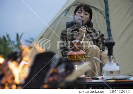 傍晚，一位年輕女子在篝火旁抽水煙 104422623