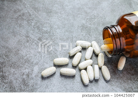 Medical pills spilling open drug bottle Medical pills spilling open drug bottle 104425007