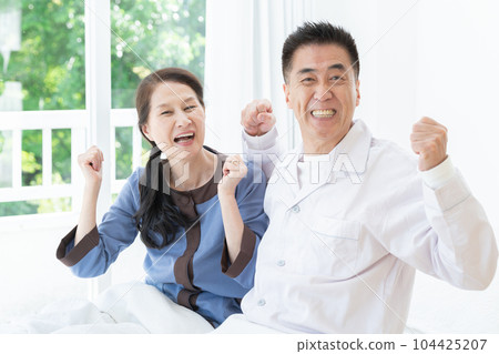 一對健康的老年夫婦早上在床上做膽量姿勢 104425207