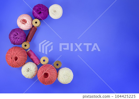 Crescent Moon Multicolored balls and bobbins of woolen yarn, sleeves of wooden thread on blue background. White, purple, pink skeins. Needlework, handmade. view from above. Copy space Crescent Moon Multicolored balls and bobbins of woolen yarn, sleeves of wooden thread on blue background. White, purple, pink skeins. Needlework, handmade. view from above. Copy space 104425225