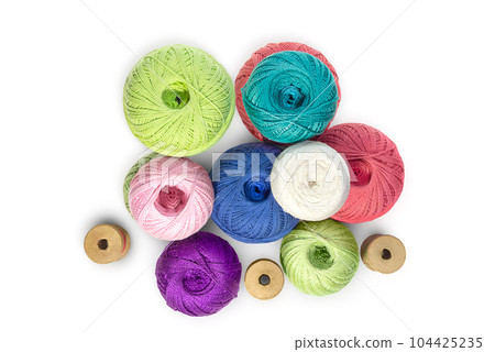 Multicolored balls and bobbins of woolen yarn, wooden thread sleeves on white isolated background. Needlework, handmade. view from above. Isolated. Copy space Multicolored balls and bobbins of woolen yarn, wooden thread sleeves on white isolated background. Needlework, handmade. view from above. Isolated. Copy space 104425235