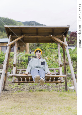 Elementary school children on a wooden swing at the campsite 104425654
