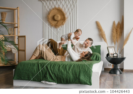 Happy family, mother and father playing with baby at home 104426443