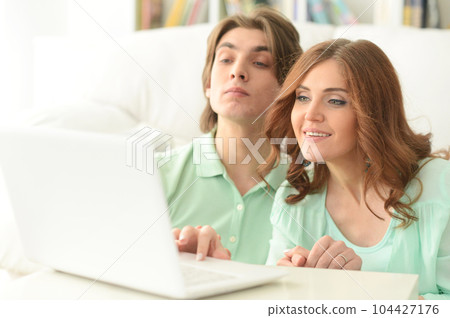 young couple using laptop 104427176