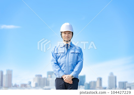 Male in work clothes, helmet, blue sky 104427229