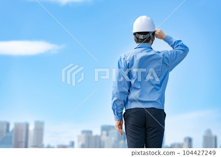Male in work clothes, helmet, blue sky Male in work clothes, helmet, blue sky 104427249