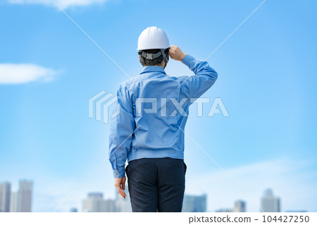 Male in work clothes, helmet, blue sky 104427250
