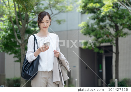 一個在戶外拿著智能手機的女人 104427526