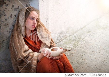 Girl with an empty lamp sits on the ground 104428554