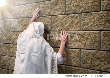 Praying person at the wall 104428555