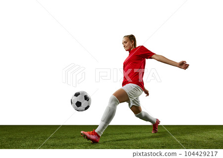 Dynamic image of female athlete, young girl, football player in motion with ball on sports field against white background 104429217
