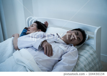 Elderly couple who seems to be hard to sleep in bed (lack of sleep / insomnia) 104430134