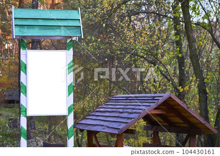 Wooden shield billboard in a green frame for text, a gazebo for a forest picnic Wooden shield billboard in a green frame for text, a gazebo for a forest picnic 104430161