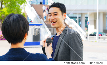 A man receiving a street interview 104430203