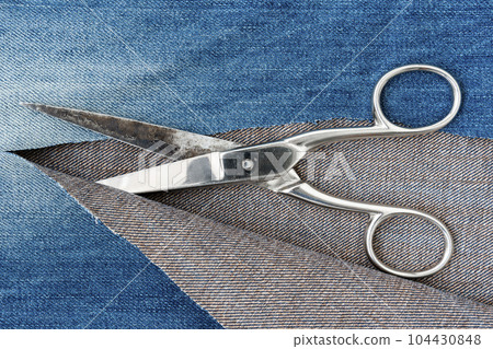 Vintage scissors and ripped denim scraps 104430848