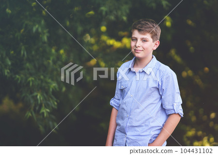 Handsome Teenager Boy Poses Outdoors, Exuding Confidence and Style in a Captivating Portrait. Happy Preteen Child. 104431102