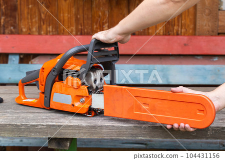 removing the casing from the chainsaw tire before starting work, close-up 104431156