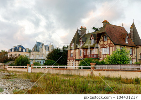 Sunrise view of coastal street of Grandcamp Maisy, a scenic French coastal town in Normandy, with fishing port, sandy beaches, and maritime traditions. 104431217